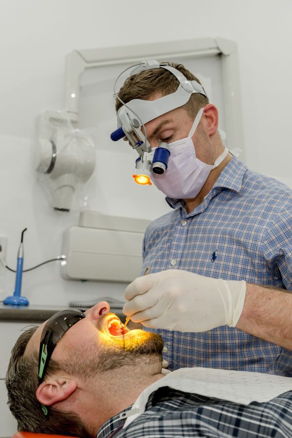 male dentist expert looking into patient's mouth